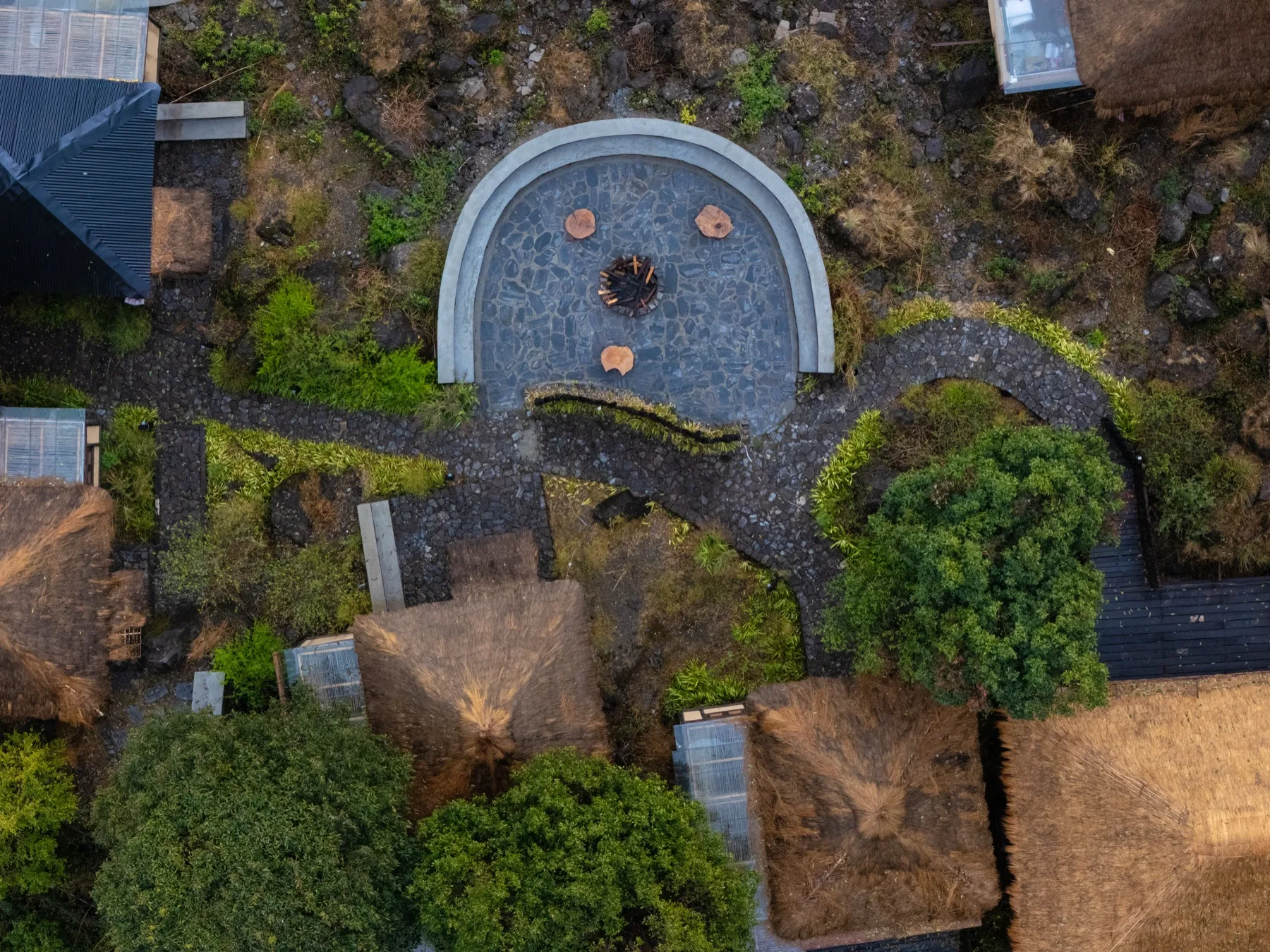 Aerial view of Kaansya — circular firepit and cottage cluster from above