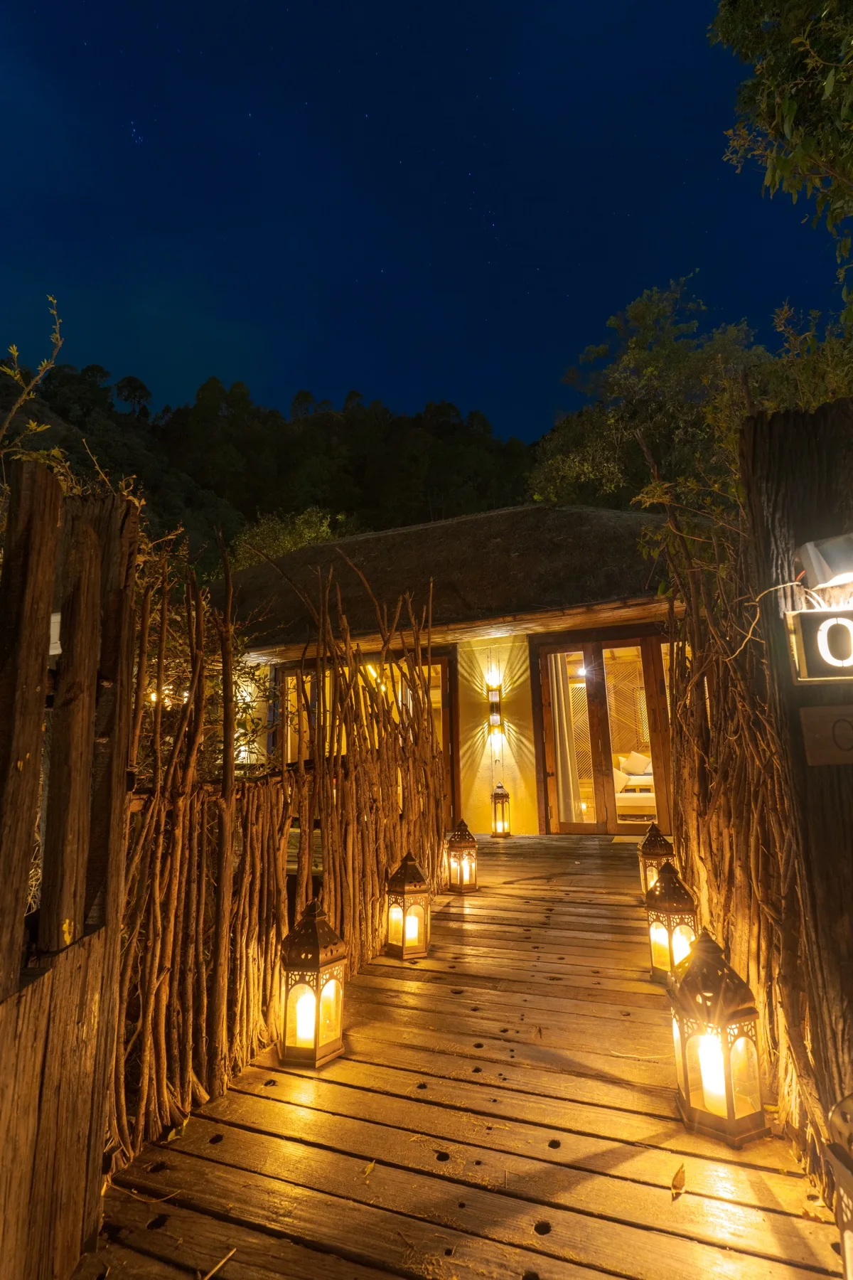 Lantern-lit walkway leading to a Kaansya villa at night